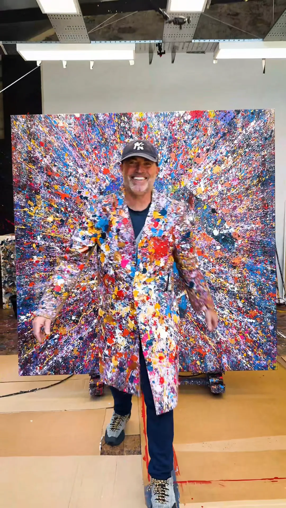 Paul Kenton in a paint-splattered coat in front of Manhattan Burst